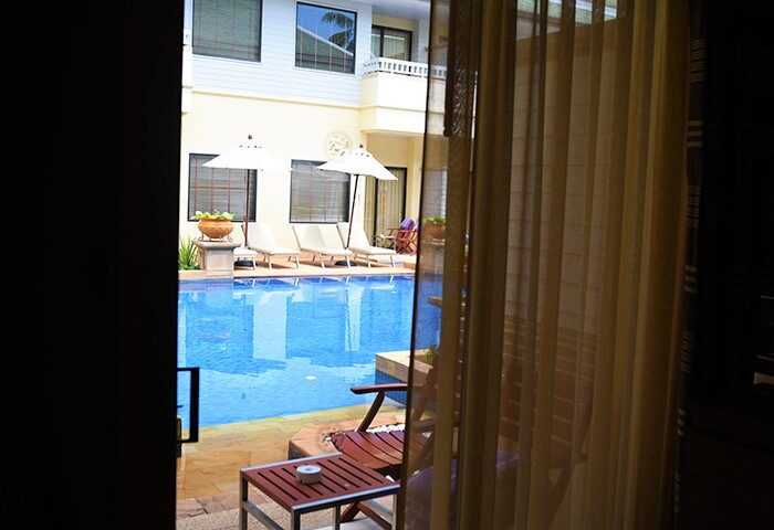 Holiday Inn Resort Phuket gay-friendly hotel view. Pool area with sun loungers and umbrellas seen from a room. Relaxing vacation spot.
