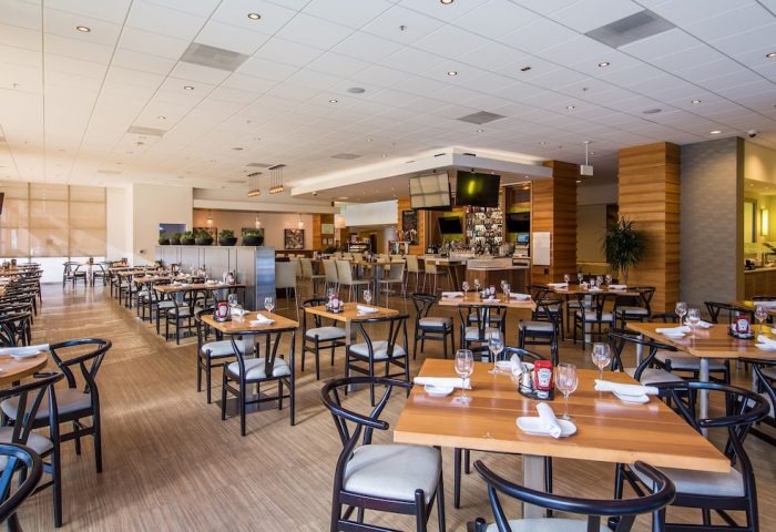 Holiday Inn San Francisco Golden Gateway gay-friendly hotel restaurant interior. Tables, chairs, bar, and TVs.