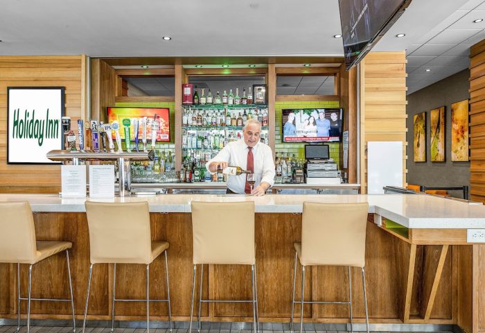 Holiday Inn San Francisco Golden Gateway bar. Bartender pours wine. Gay-friendly hotel with drinks, beer taps, and TV.