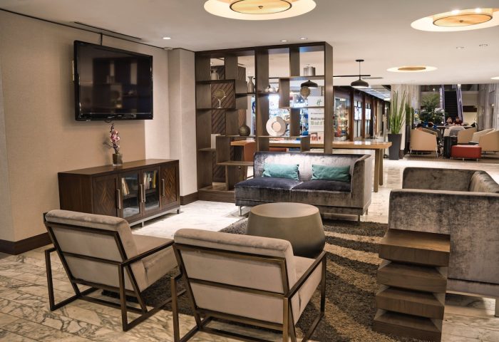 Holiday Inn Toronto Downtown Centre's stylish lounge. Gay-friendly hotel with modern seating, TV, and decorative shelving. Relaxing space.