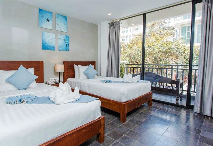 Home Chic Hotel gay-friendly room. Twin beds with blue accents, balcony view. Modern design, comfortable stay. Perfect for gay travelers.