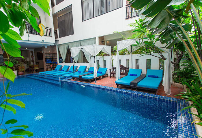 Home Chic Hotel's pool area. Gay-friendly hotel with blue loungers and clear water. A tropical oasis for gay men travel.