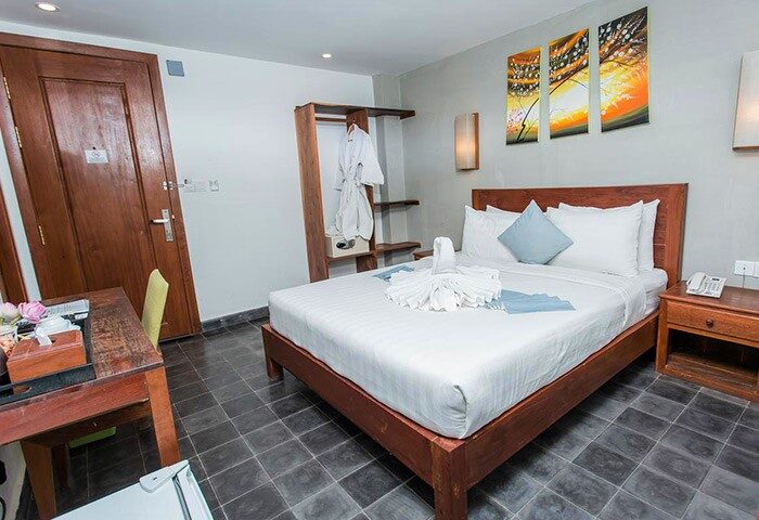 Home Chic Hotel's gay-friendly room. Bed with swan towels, desk, closet, and modern art. A comfortable stay for gay travelers.