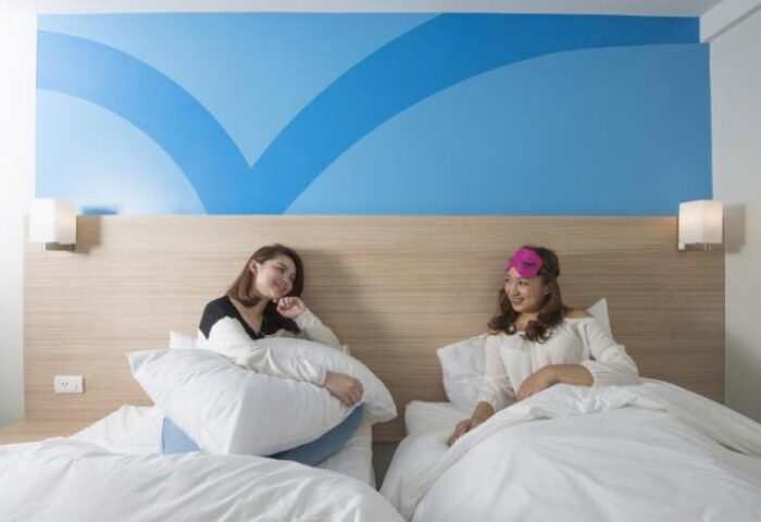 Hop Inn Hotel Ermita Manila: Two women in a room at this gay-friendly hotel. One wears a sleep mask. Clean, modern design.