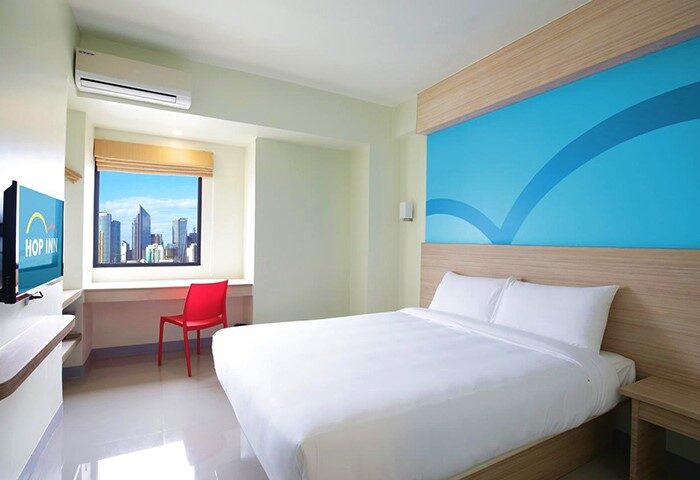 Hop Inn Hotel Makati Avenue Manila room. Gay-friendly hotel with city view. Clean, modern design. Perfect for gay travel in Manila.