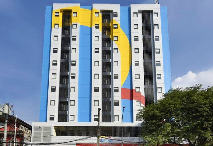 Hop Inn Hotel Tomas Morato, Quezon City facade. Gay-friendly hotel with colorful design. Modern building with windows. Budget-friendly stay.