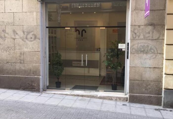 Hostal Pizarro entrance. Gay-friendly hotel with glass doors and reception visible inside. A welcoming space for gay travelers.