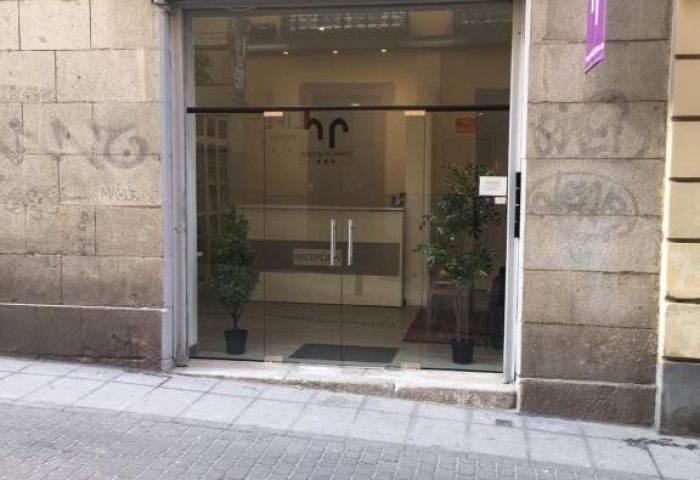 Hostal Pizarro entrance. Gay-friendly hotel with glass doors and reception visible inside. A welcoming space for gay travelers.