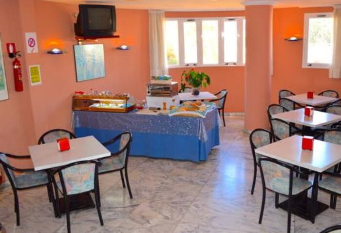 Gay-friendly Hostal Residencia Molins Park dining area. Tables and chairs are set for breakfast. A buffet is available for guests.