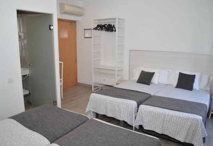 Gay-Friendly Hotel Hostal San Lorenzo room. Triple beds, minimalist decor, bathroom with frosted glass door. Ideal for gay travelers.