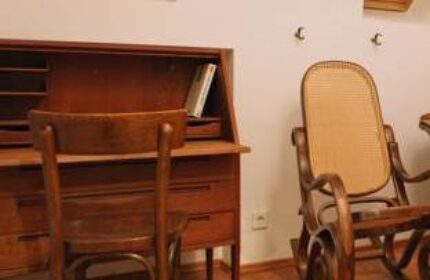 Hostel die Wohngemeinschaft room: Wooden desk, chair, & rocking chair. Gay-friendly hotel/hostel for gay men travel advice.