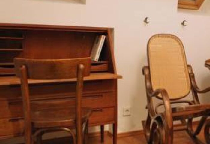 Hostel die Wohngemeinschaft room: Wooden desk, chair, & rocking chair. Gay-friendly hotel/hostel for gay men travel advice.