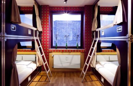 Hostel die Wohngemeinschaft room. Gay-friendly hotel with bunk beds, ladders, and a window. Unique hostel for gay travelers.