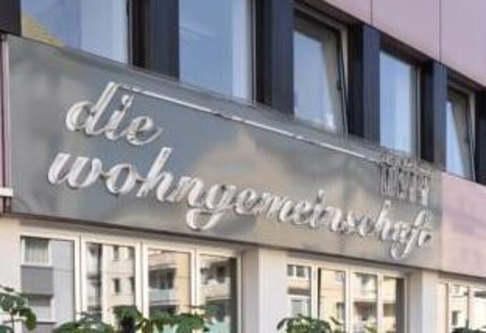 Hostel die Wohngemeinschaft facade. Gay-friendly hotel for gay men travel. Signage with die Wohngemeinschaft text. Modern building.