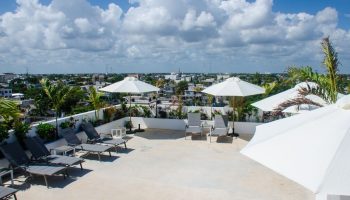 Hotel 52, a gay-friendly hotel. Rooftop terrace view with lounge chairs, umbrellas, and city skyline. Ideal for gay travelers' relaxation.
