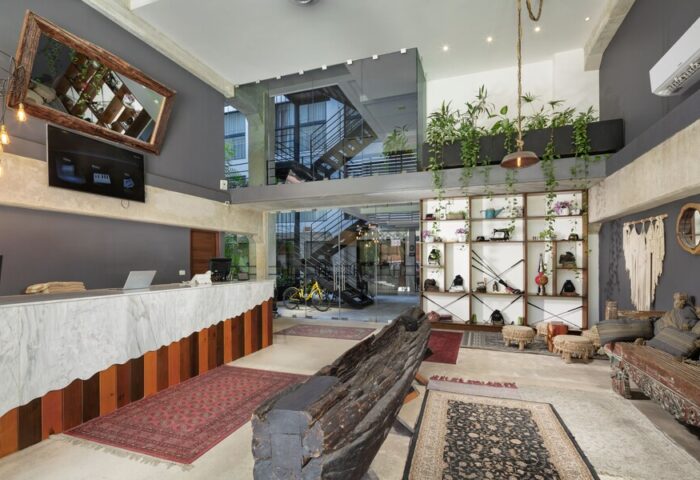 Hotel 52, a gay-friendly hotel. Unique lobby area with eclectic decor, plants, rugs, and interesting furniture. Hotel interior design.