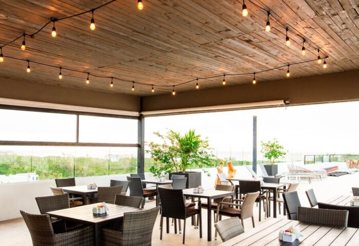 Hotel 52, a gay-friendly hotel: Outdoor dining area with tables, chairs, string lights, and a view. Perfect for gay travelers.