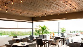 Hotel 52, a gay-friendly hotel: Outdoor dining area with tables, chairs, string lights, and a view. Perfect for gay travelers.