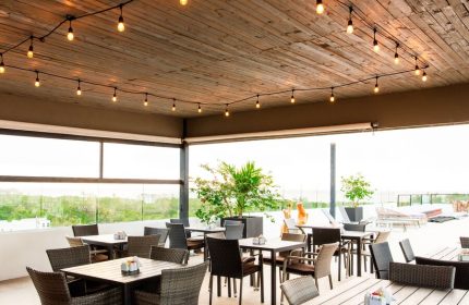 Hotel 52, a gay-friendly hotel: Outdoor dining area with tables, chairs, string lights, and a view. Perfect for gay travelers.
