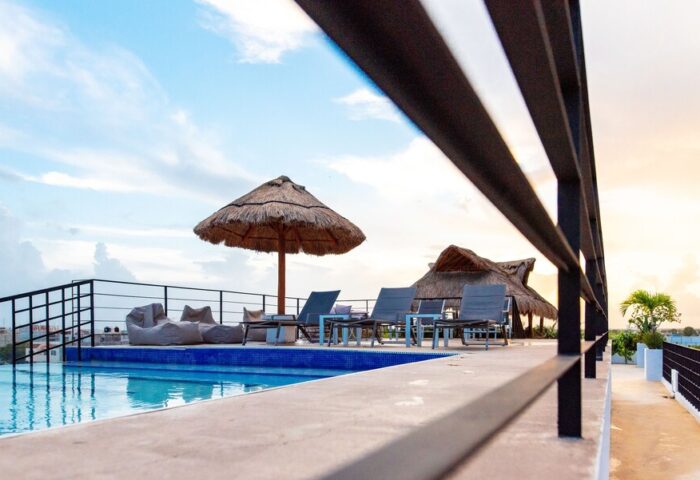 Hotel 52's gay-friendly rooftop pool with thatched umbrellas, lounge chairs, and beanbag chairs. A perfect gay travel destination.