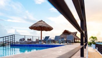 Hotel 52's gay-friendly rooftop pool with thatched umbrellas, lounge chairs, and beanbag chairs. A perfect gay travel destination.