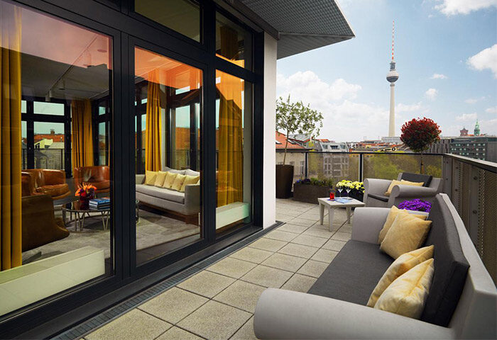 Hotel AMANO's pet-friendly, gay-friendly room with balcony. Berlin skyline view. Modern design, comfortable seating. Ideal for gay men travelers.