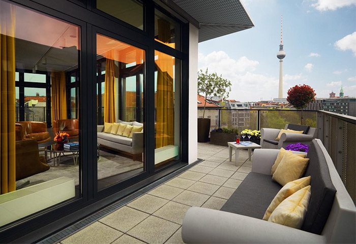Hotel AMANO's pet-friendly, gay-friendly room with balcony. Berlin skyline view. Modern design, comfortable seating. Ideal for gay men travelers.