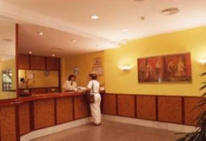 Hotel Alameda's reception area. A guest checks in at this gay-friendly hotel. The warm ambiance welcomes travelers.