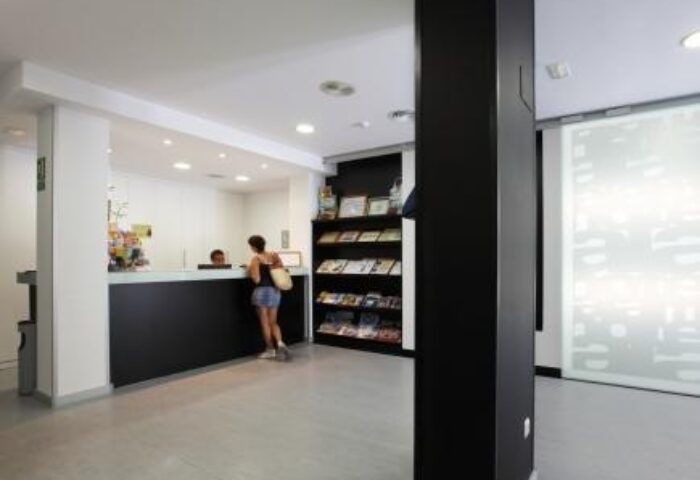 Hotel Alameda's modern lobby. A guest checks in at the front desk of this gay-friendly hotel. Travel advice and brochures are available.