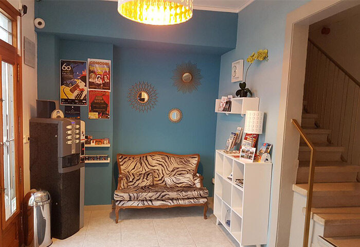 Hotel Alexandra's lobby, a gay-friendly hotel. Interior with a tiger print couch, vending machine, and tourist information. Welcoming space.