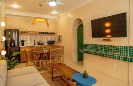 Hotel Amaca Puerto Vallarta Adults Only suite. Gay-friendly hotel interior with kitchenette, dining area, and TV. Modern design.