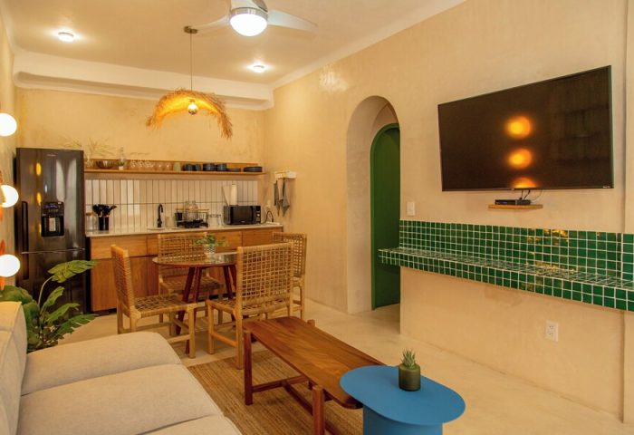 Hotel Amaca Puerto Vallarta Adults Only suite. Gay-friendly hotel interior with kitchenette, dining area, and TV. Modern design.