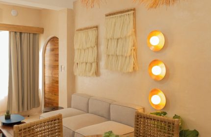 Hotel Amaca Puerto Vallarta Adults Only suite. Gay-friendly hotel room with woven chairs, table, sofa, and straw decor. Interior design.