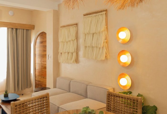 Hotel Amaca Puerto Vallarta Adults Only suite. Gay-friendly hotel room with woven chairs, table, sofa, and straw decor. Interior design.
