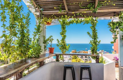 Hotel Amaca Puerto Vallarta Adults Only gay-friendly hotel view. Ocean view from the terrace with stools, plants, and a wooden bar.