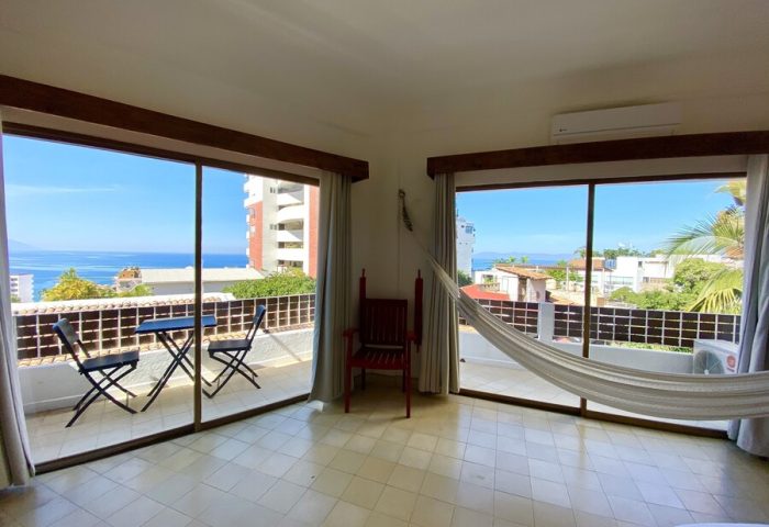 Hotel Amaca Puerto Vallarta Adults Only room. Gay-friendly hotel balcony view, hammock, table, and chairs. Perfect for a relaxing vacation.