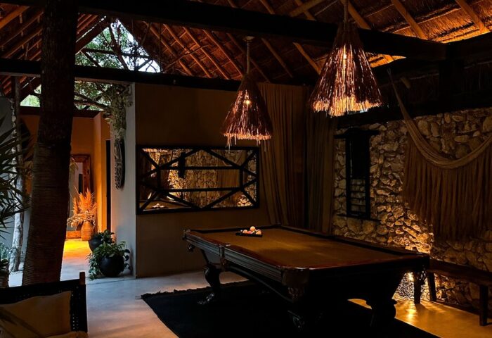 Hotel Bardo Adults Only gay-friendly hotel interior. Billiard room with thatched roof, stone wall, hammock. Relaxing space for gay travelers.