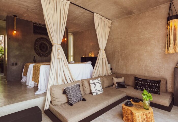 Hotel Bardo Adults Only, a gay-friendly hotel. Interior view of a suite with massage beds, curtains, and a comfortable seating area.