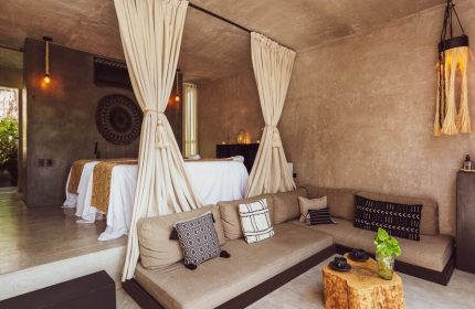 Hotel Bardo Adults Only, a gay-friendly hotel. Interior view of a suite with massage beds, curtains, and a comfortable seating area.