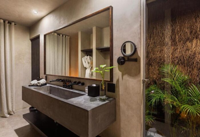 Hotel Bardo Adults Only bathroom. Modern design, concrete sink, large mirror, and tropical plants. Gay-friendly hotel for a relaxing getaway.