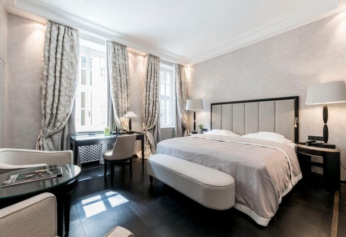 Hotel Bayerischer Hof room. Gay-friendly hotel bedroom with a large bed, desk, chairs, and elegant decor. Upscale Munich lodging.
