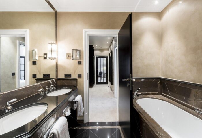 Hotel Bayerischer Hof gay-friendly hotel bathroom. Double sink vanity, marble accents, and a glimpse into the suite. Upscale travel.