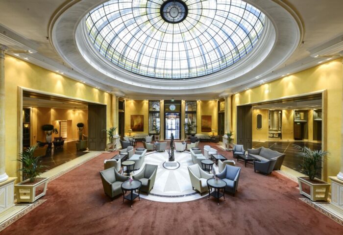 Hotel Bayerischer Hof's grand lobby. Seating area beneath a glass dome. Gay-friendly hotel, luxury travel.