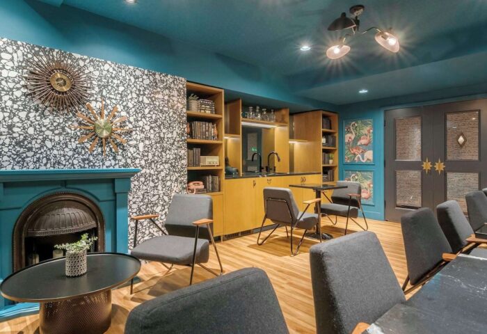 Hotel Belmont Vancouver Mgallery's lounge area. Gay-friendly hotel with stylish decor, including a fireplace, flamingo art, and modern seating.