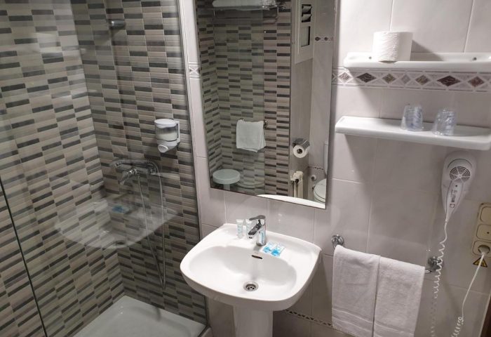 Hotel Bilbaino's bathroom. Gay-friendly hotel with shower, sink, mirror, and amenities. A comfortable space for your stay in Bilbao.