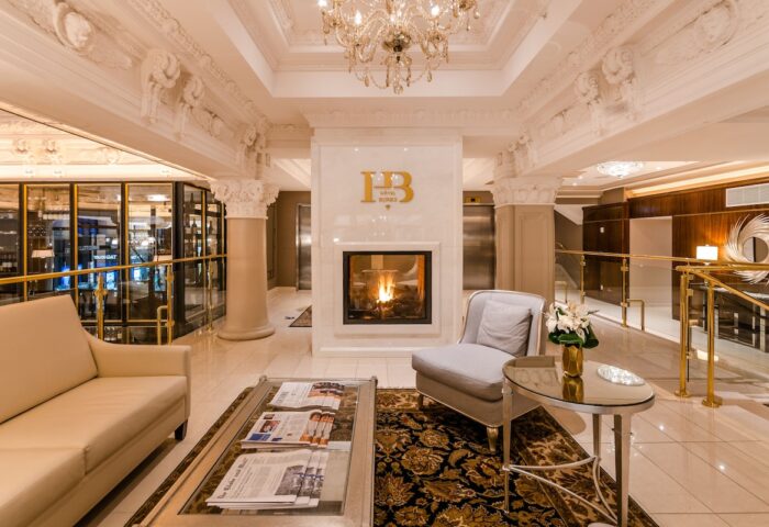 Hotel Birks Montreal's luxurious lobby. Fireplace, seating area, and ornate details create an inviting ambiance. Gay-friendly hotel.