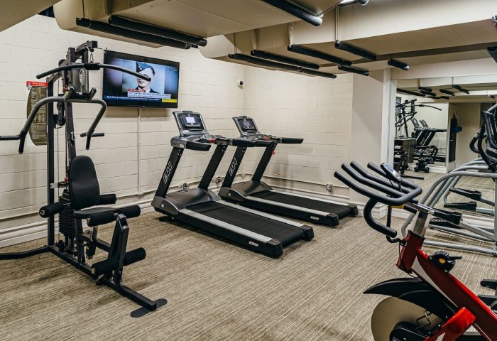 Hotel Birks Montreal gym. Gay-friendly hotel fitness center with treadmills, weight machines, and TV. Exercise equipment for hotel guests.