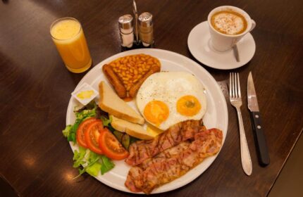Hotel CC gay-friendly hotel breakfast: fried eggs, bacon, beans, toast, salad, orange juice, and coffee. A delicious start to your gay travel day.