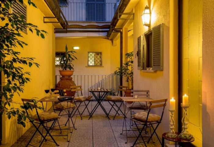 Hotel Canada's gay-friendly courtyard at night. Tables with candles, wine glasses, and plants create a romantic, inviting atmosphere.