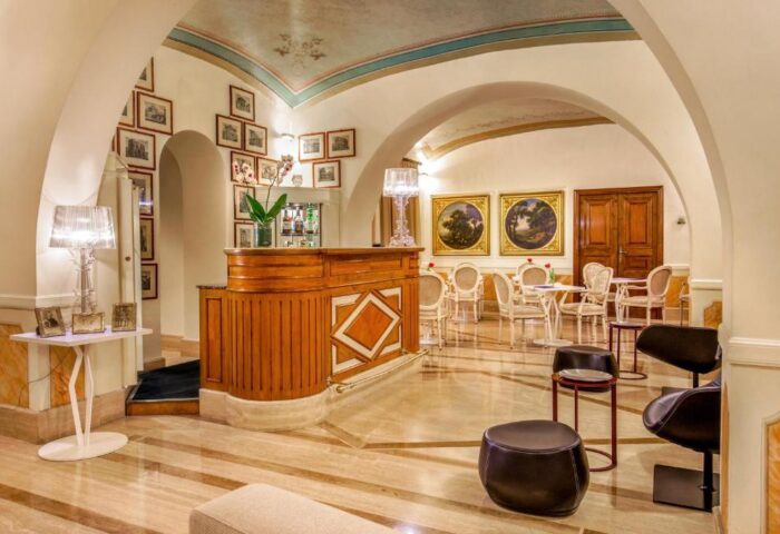 Hotel Canada's gay-friendly lounge area. Features a bar, tables, chairs, and artwork. A welcoming space for LGBTQ+ travelers.